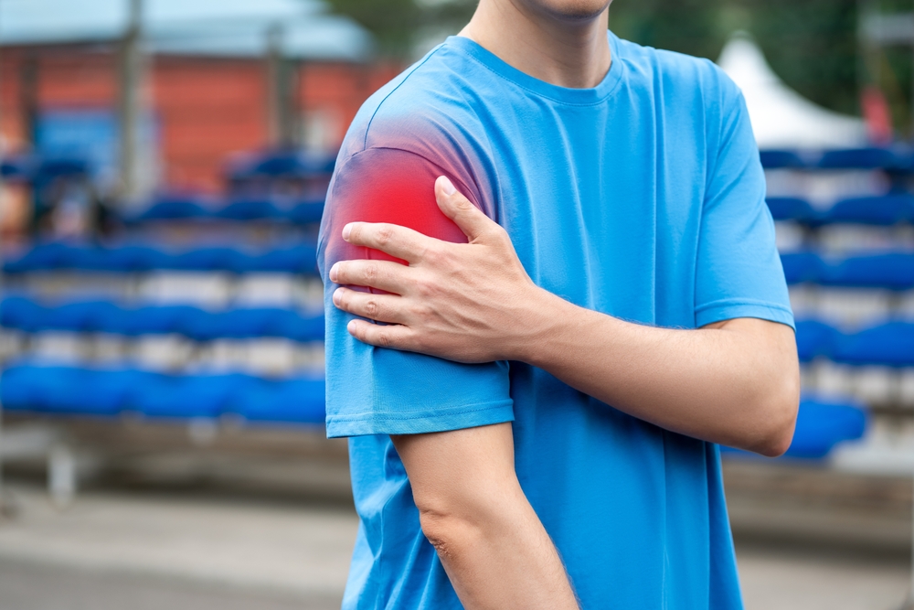 Person experiencing shoulder pain in Brooklyn